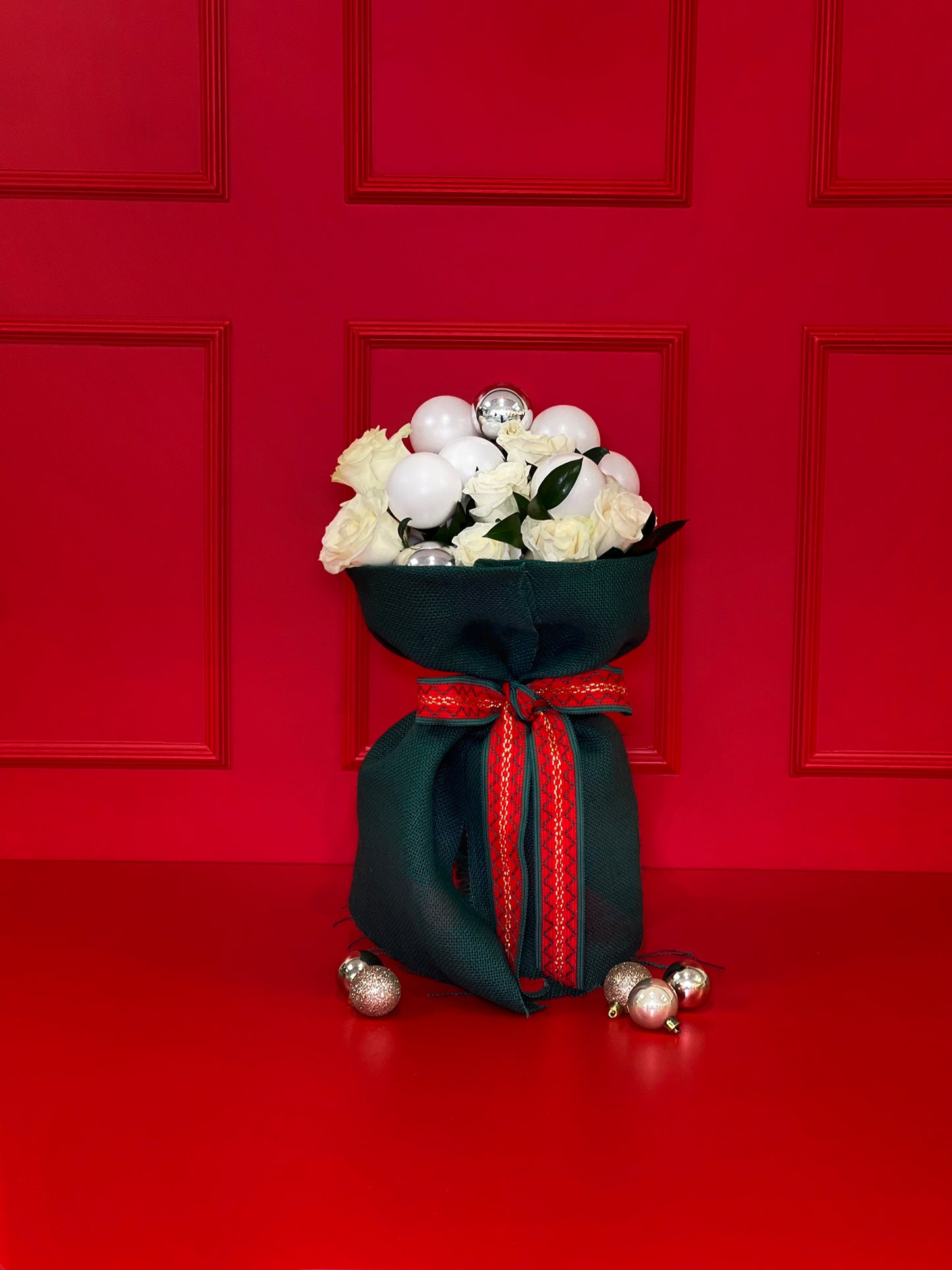 BOUQUET COM ROSAS E BOLAS NATALÍCIAS ENVOLVIDO NO TECIDO DE JUTA DE LINHO CRU VERDE